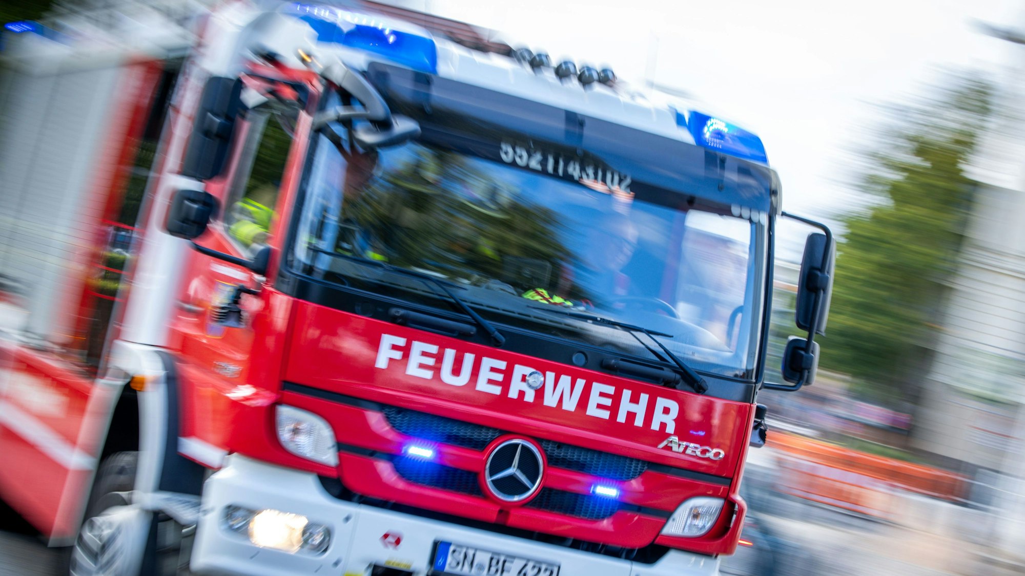 Löschfahrzeuge der Berufsfeuerwehr fahren mit Blaulicht zu einem Einsatz.