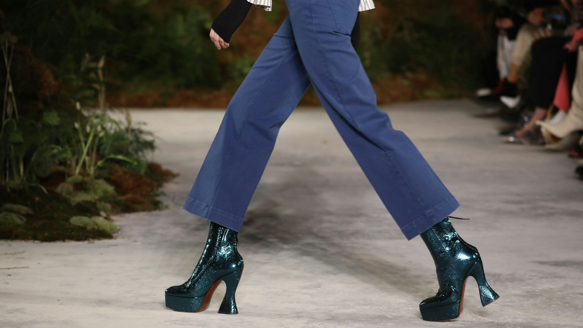 Eine Frau mit hochhackigen schwarzen Stiefeln.