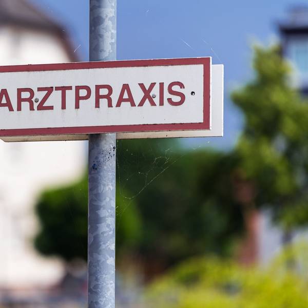 Ein Schild «Arztpraxis» steht an der Straße.