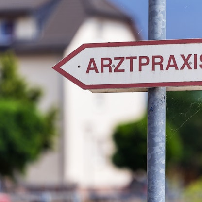 Ein Schild «Arztpraxis» steht an der Straße.