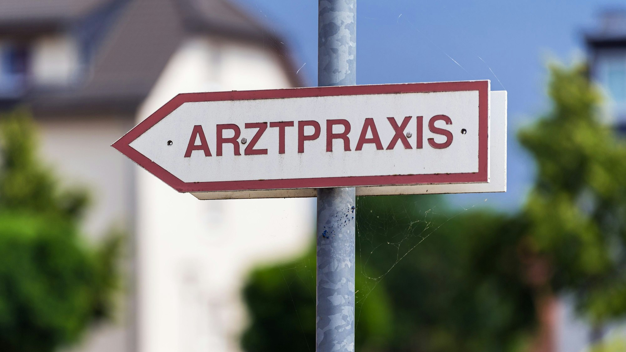 Ein Schild «Arztpraxis» steht an der Straße.