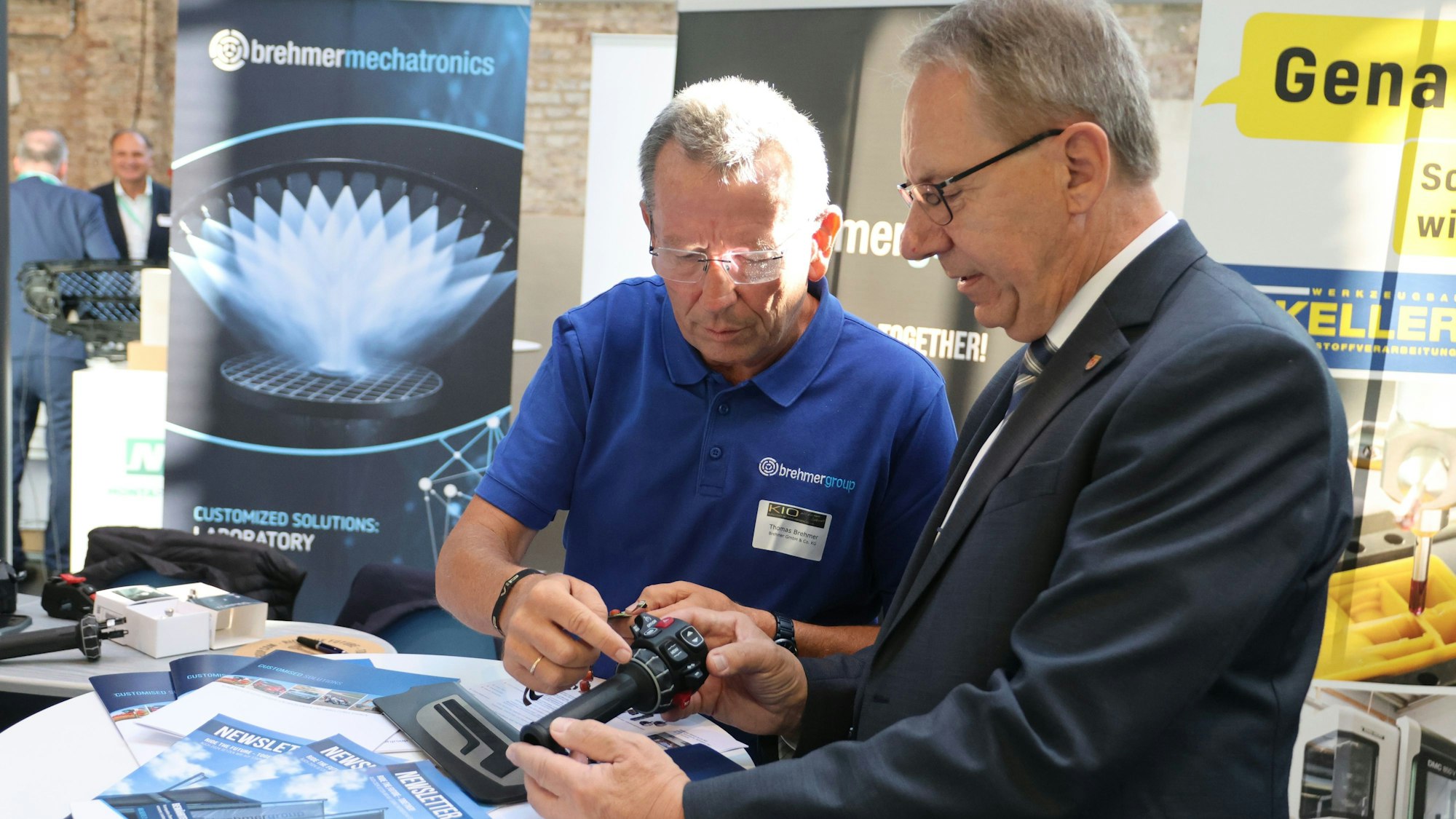 Thomas Brehmer zeigt Landrat Jochen Hagt einen Motorradgriff.