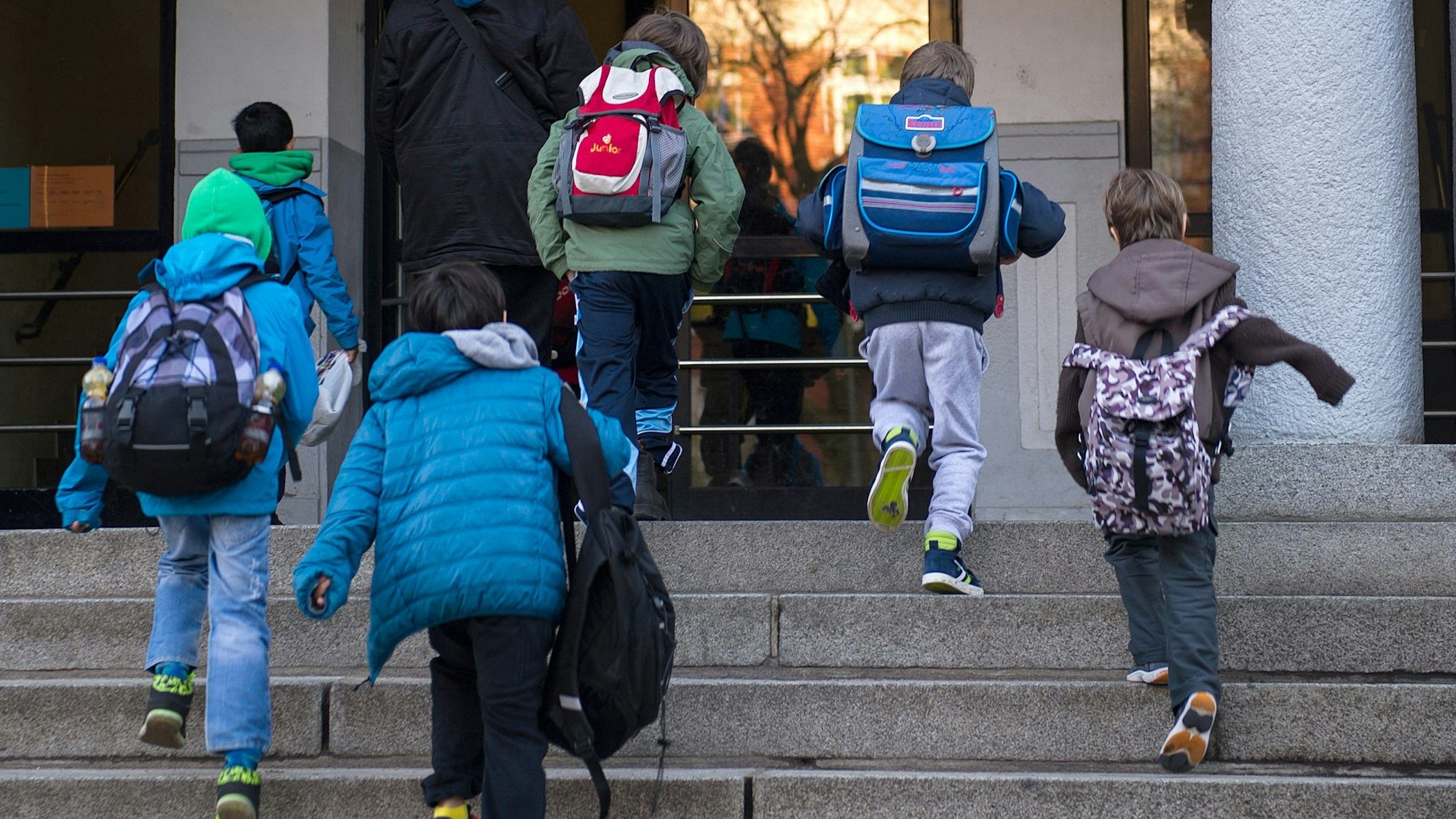 Schüler betreten ein Schulgebäude in Hamburg. (Archivbild)