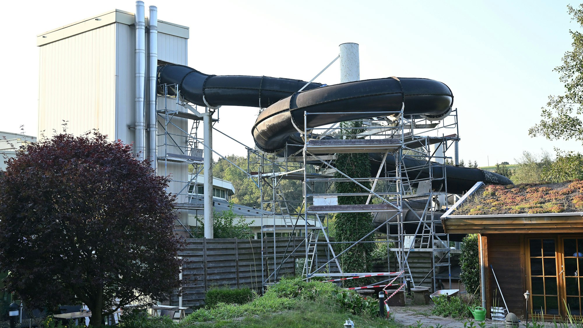 Das Foto zeigt die Außenanlagen des Schwimmbads mit der Rutsche