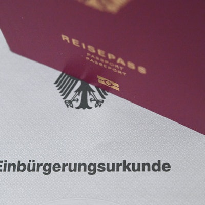 Reisepass steht auf einer Einbürgerungsurkunde.