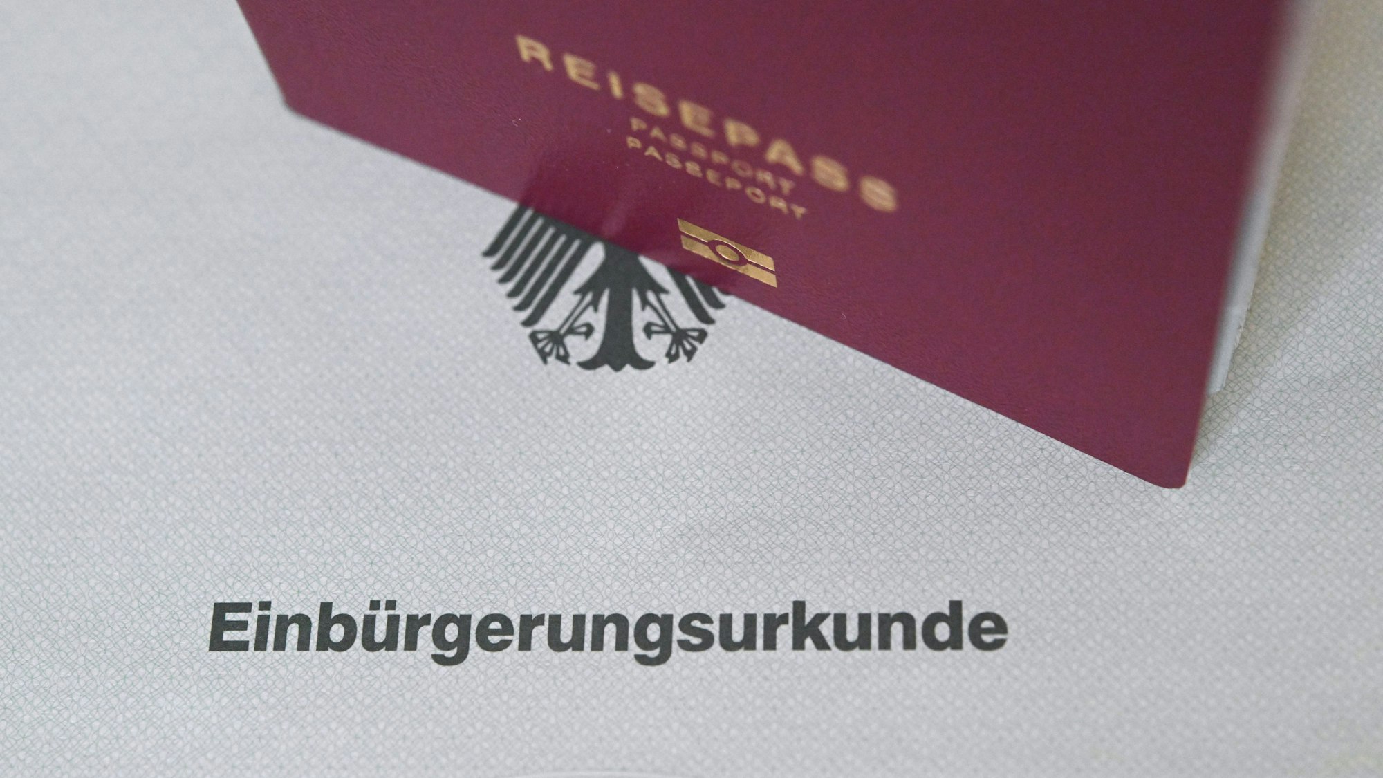 Reisepass steht auf einer Einbürgerungsurkunde.
