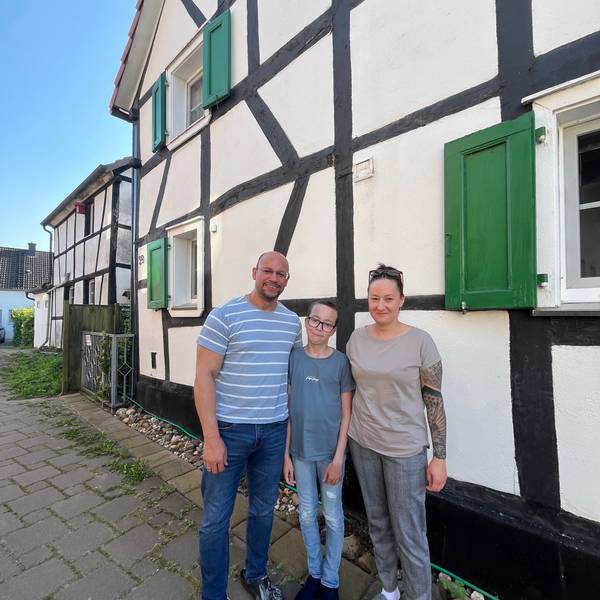 Familie vor Fachwerkhaus