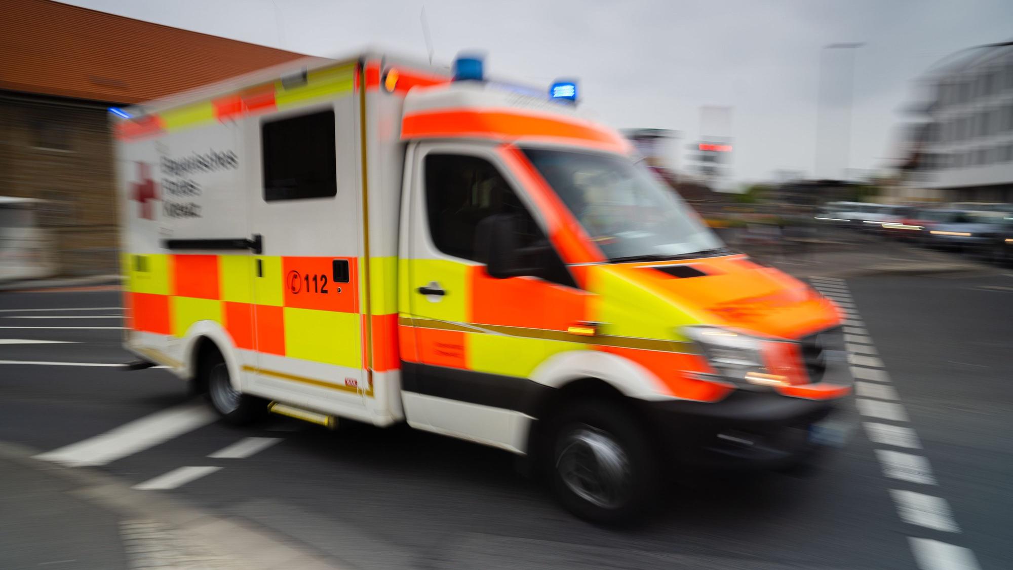 Ein Rettungswagen fährt mit Blaulicht durch eine Straße.