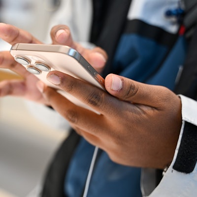 Ein Mann schaut sich im Apple-Geschäft ein neues iPhone 16 an.