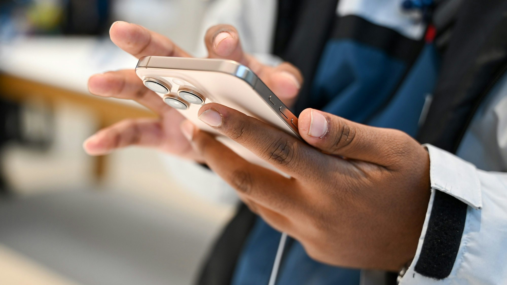Ein Mann schaut sich im Apple-Geschäft ein neues iPhone 16 an.