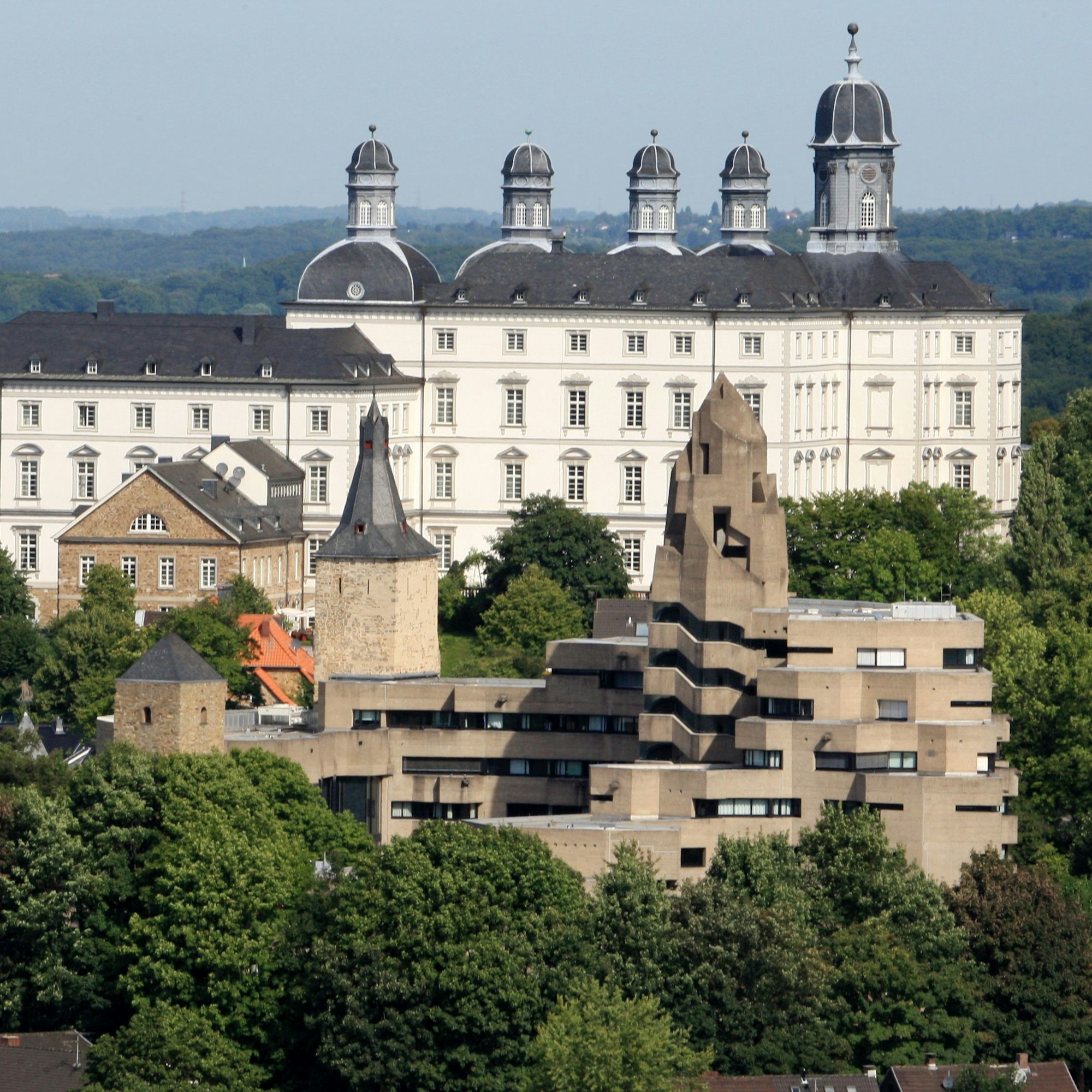 Hinter dem Bensberger Rathaus ist Schloss Bensberg zu sehen.