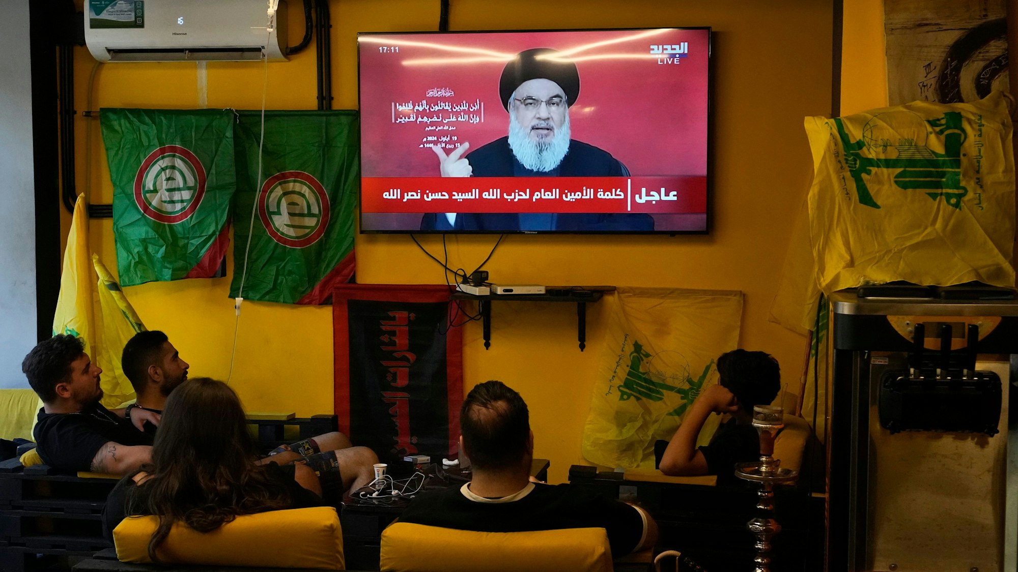 Menschen verfolgen die Rede des Hisbollah-Führers Hassan Nasrallah, während sie in einem Café in einem südlichen Vorort sitzen.