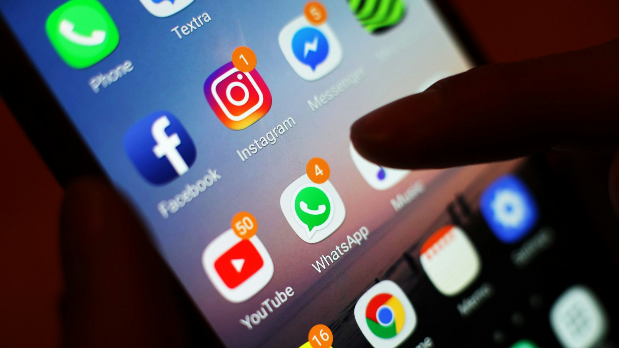 Ein Blick auf ein Handy mit den verschiedenen Social Media Apps, wie Facebook, Instagram, WhatsApp.