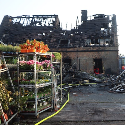 Auf dem Foto sind die niedergebrannte Gärtnerei und das Wohnhaus zu sehen.