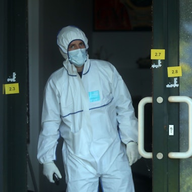 Einschusslöcher an einer Scheibe eines Uhrengeschäfts. Sie sind versehen mit gelben Markierungszetteln der Polizei.