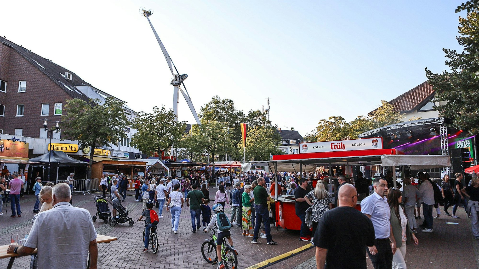 Viele Menschen befinden sich auf einem Platz und feiern ein Volksfest.