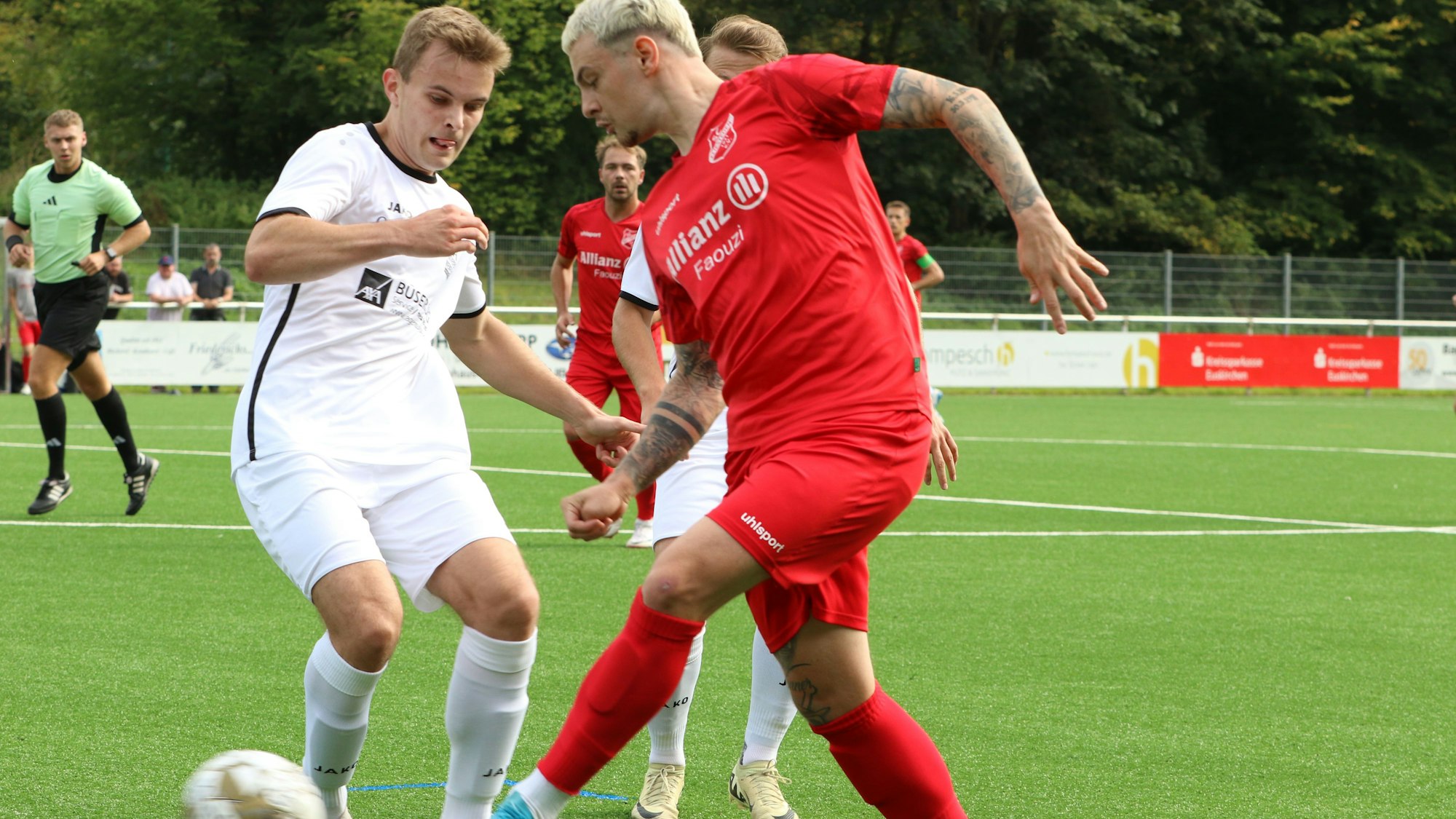 Ein Fußballspieler legt den Ball an seinem Gegner vorbei.