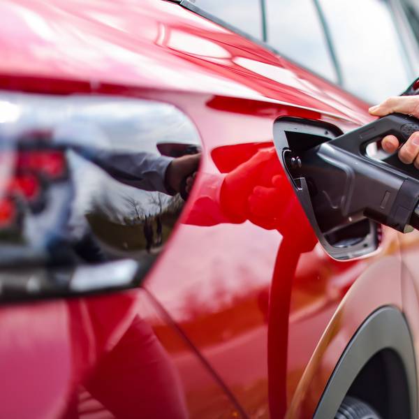 Ein rotes E-Auto wird aufgeladen.