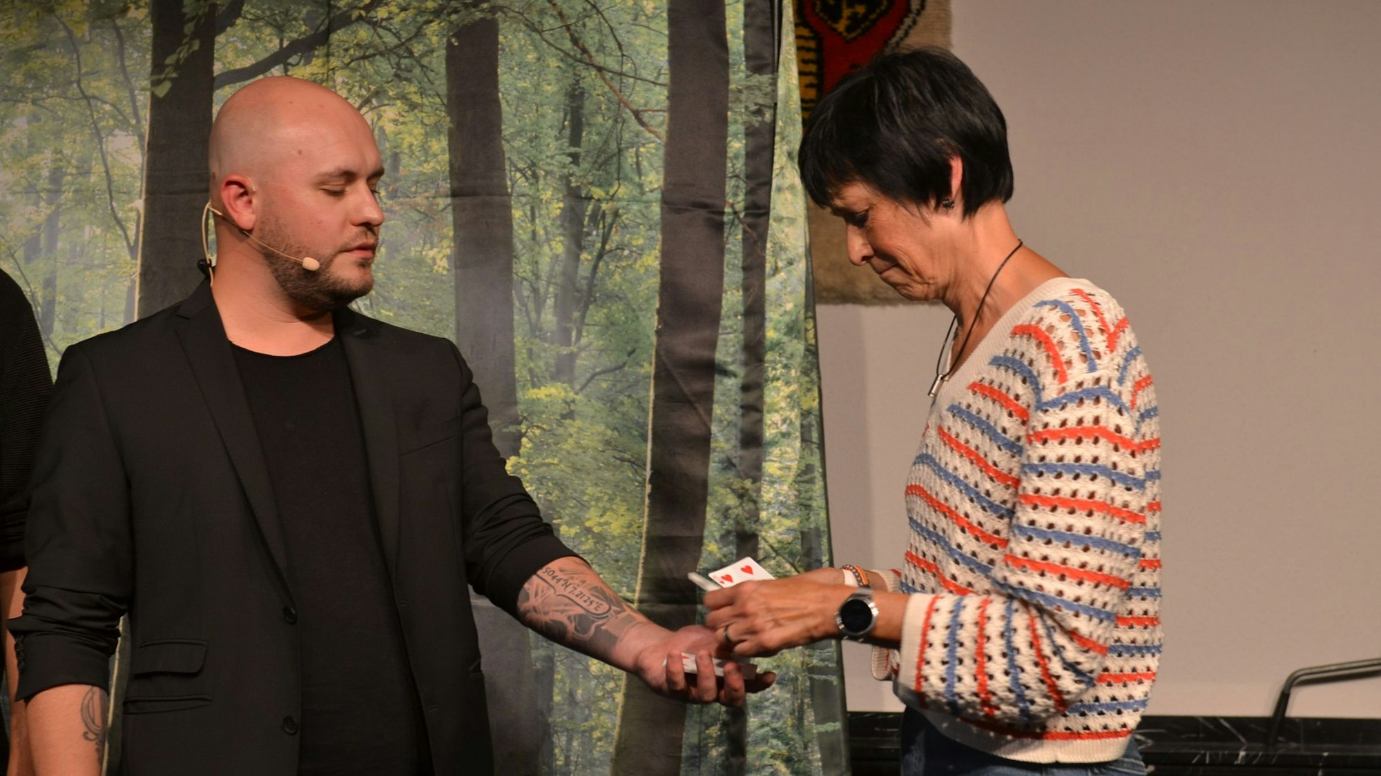 Luke Dimon macht einen Zaubertrick mit Karten mit einer Besucherin.