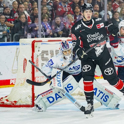 Haie-Stürmer Marco Münzenberger (M.) kämpft im Duell mit Mannheims Torwart Arno Tiefensee und Nick Cicek (r.) um den Puck.