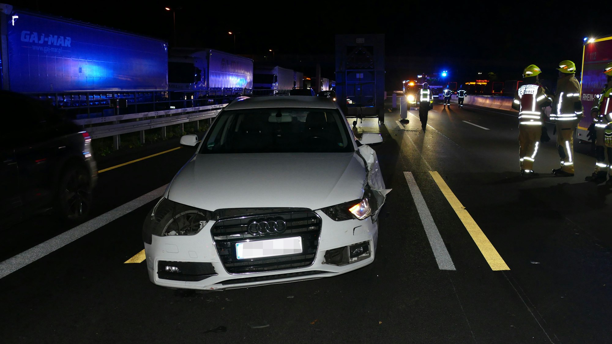 Ein beschädigtes weißes Auto auf einer Autobahn.