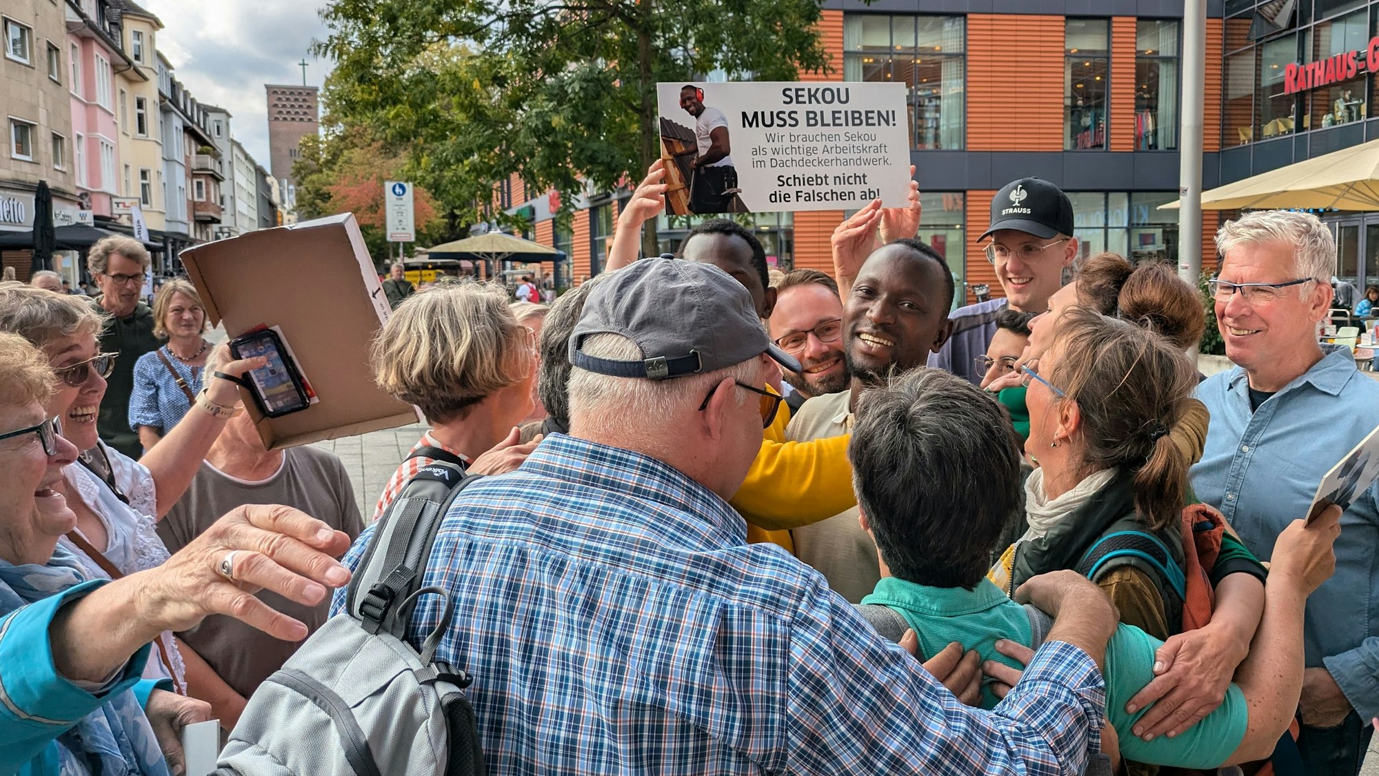 Ein Mann wird von anderen Leuten umringt und gefeiert.