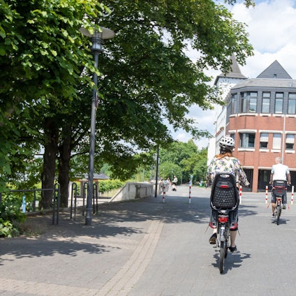 Eine Radfahrerin auf der Rheinpromenade