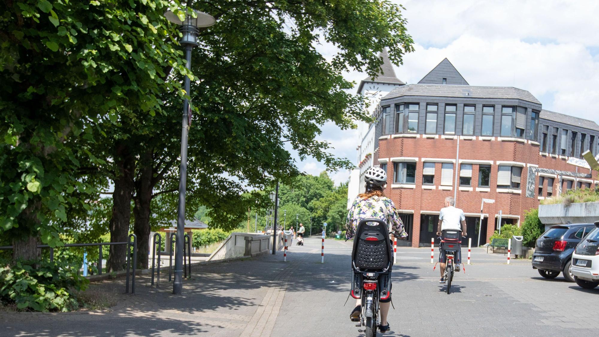 Eine Radfahrerin auf der Rheinpromenade