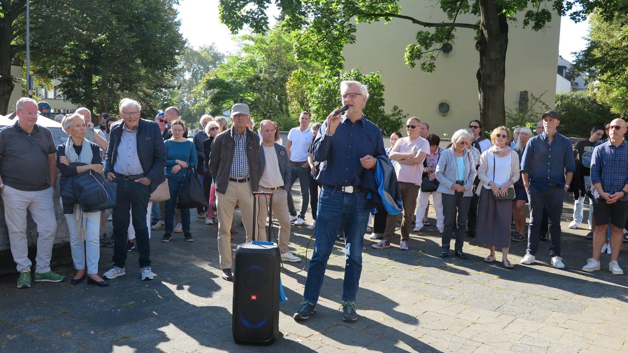 Bezirksbürgermeister Andreas Hupke spricht am Mikro vor Anwohnern des Agnesviertels.