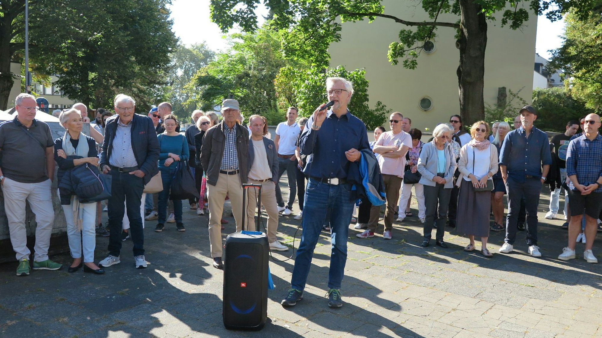 Bezirksbürgermeister Andreas Hupke spricht am Mikro vor Anwohnern des Agnesviertels.