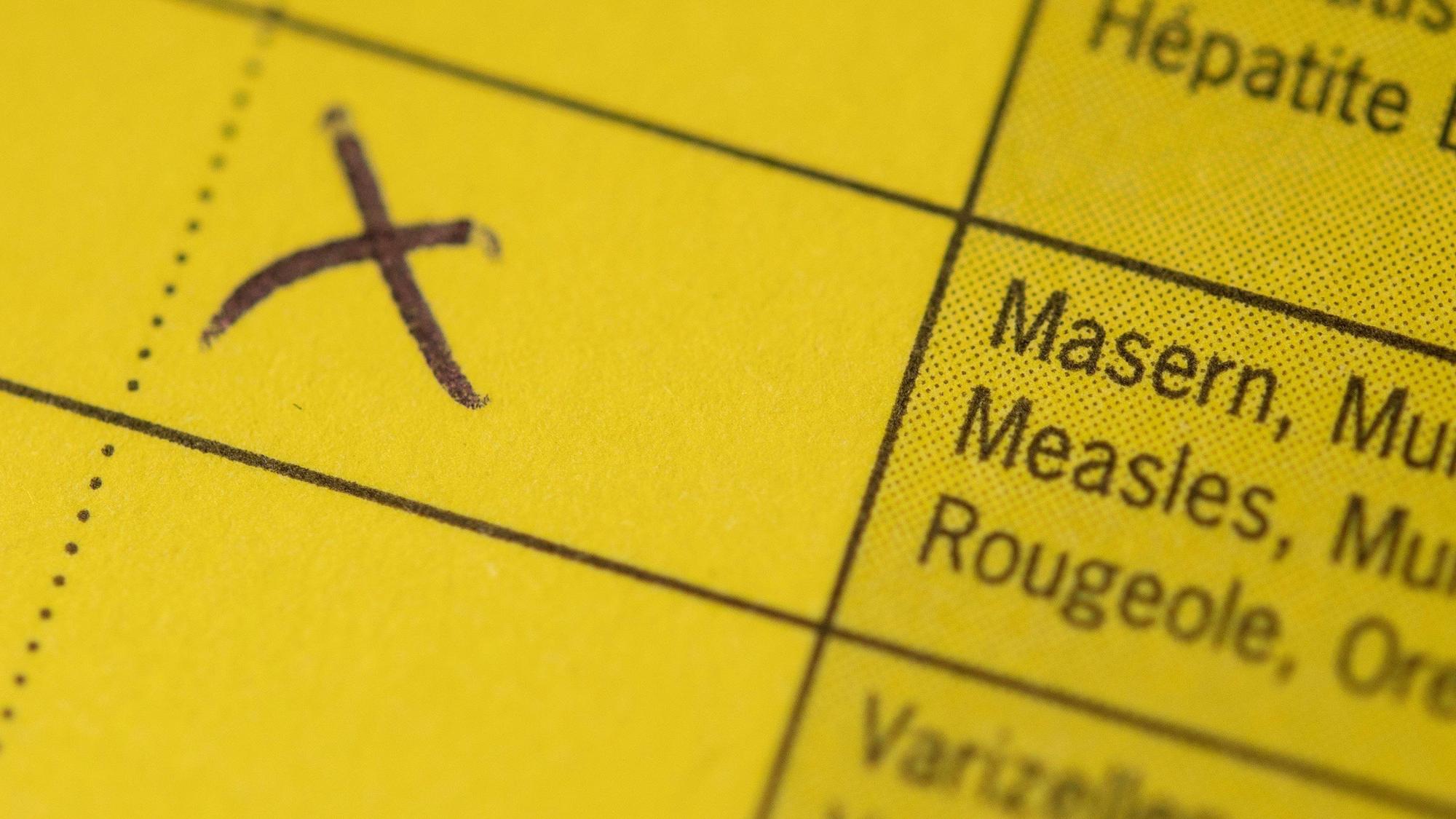 Die Masern-Impfung ist in einem Impfpass angekreuzt.
