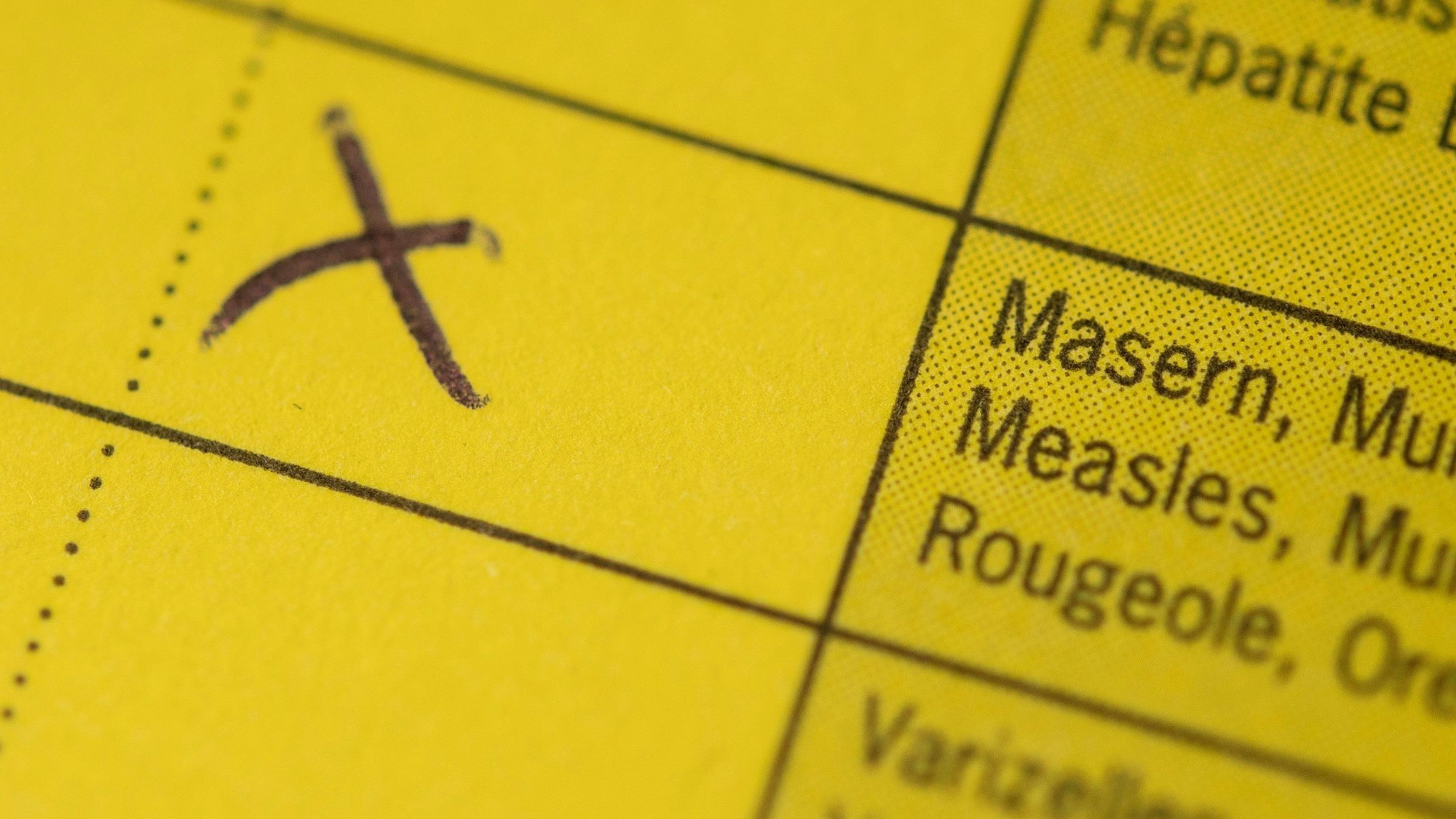 Die Masern-Impfung ist in einem Impfpass angekreuzt.