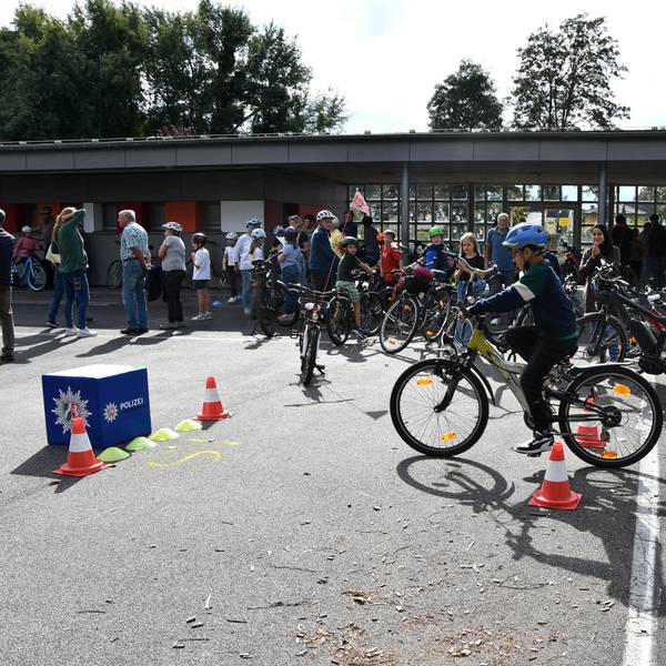Ein Kind fährt auf einem Schulhof Fahrrad.
