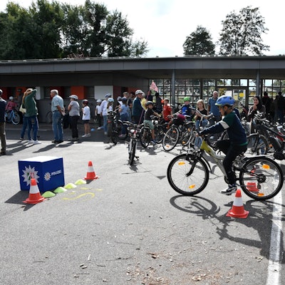 Ein Kind fährt auf einem Schulhof Fahrrad.