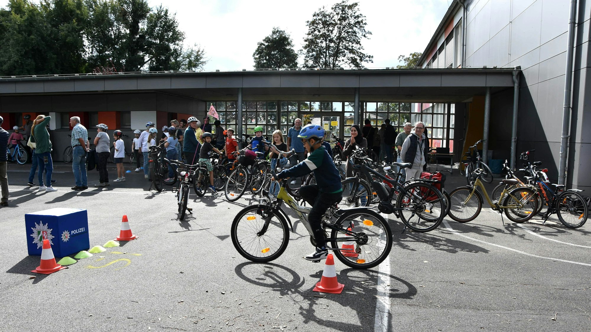 Ein Kind fährt auf einem Schulhof Fahrrad.