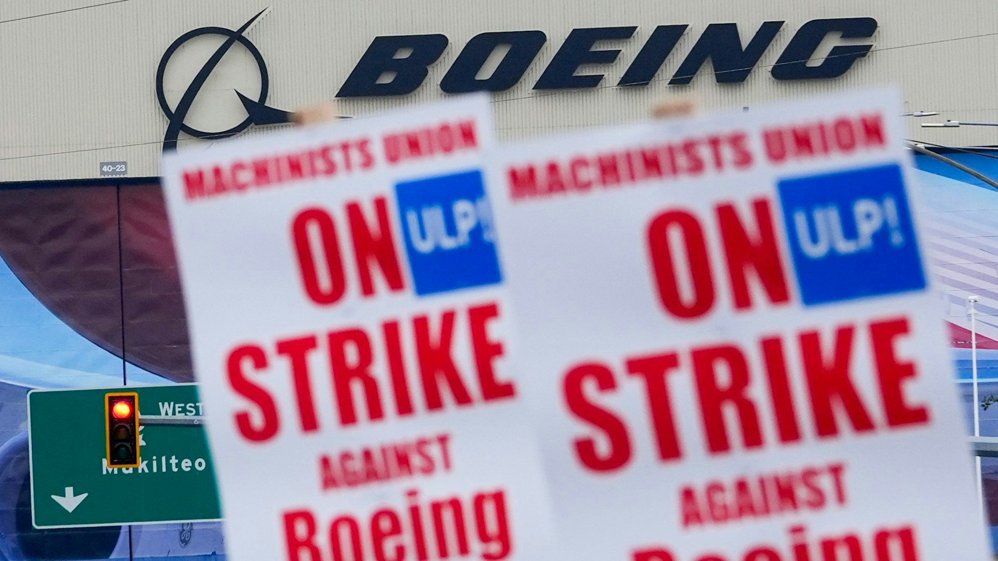 Boeing-Beschäftigte schwenken vor dem Werk in Everett, USA, Streikpostenschilder.