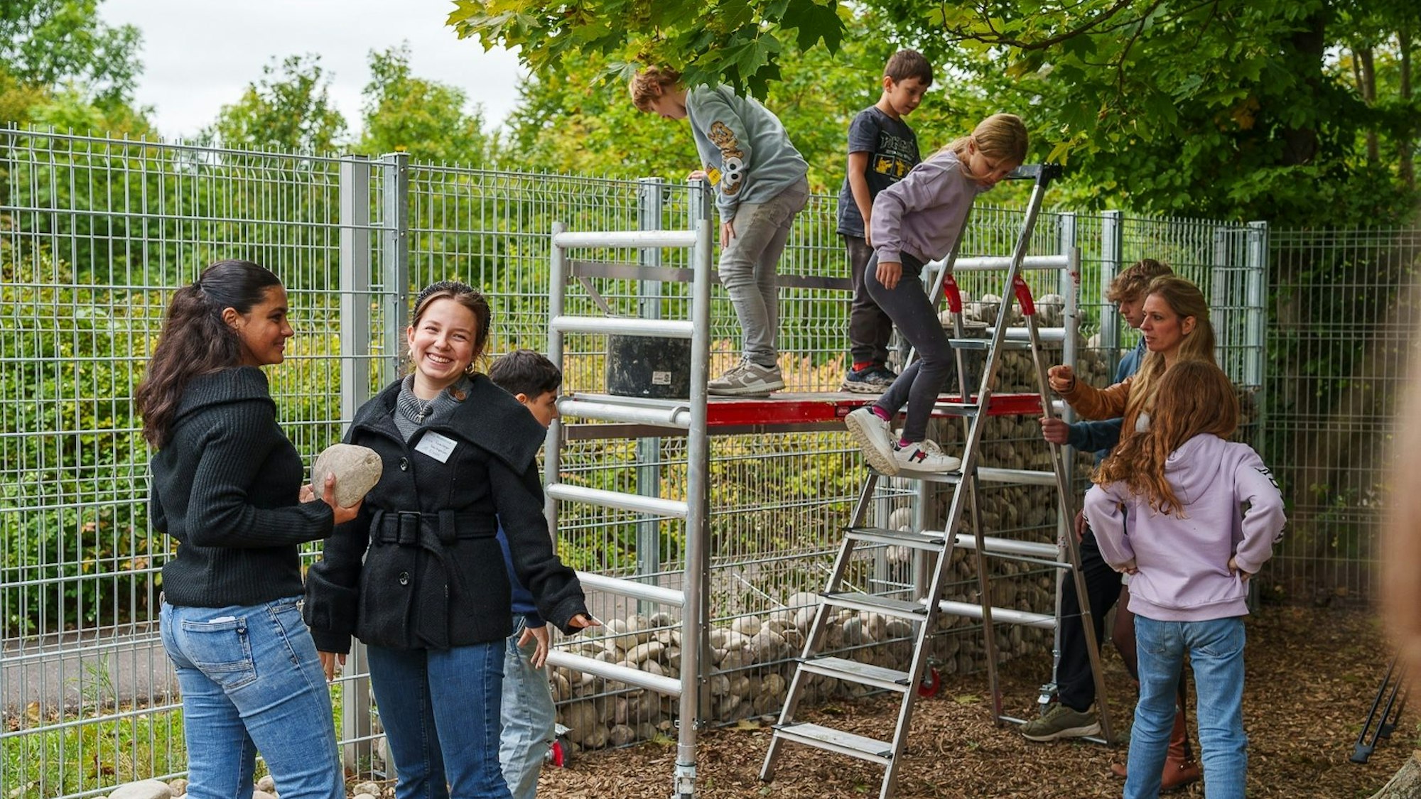 Schüler der Freien Naturschule Köln befüllen den ersten Abschnitt von Kölns größtem Insektenhotels mit Steinen.