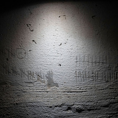 Blick auf Ziffern, die zur Zeitmessung von Häftlingen in die Wand eines Kellers in einem Gebäude in Cherson geritzt wurden, das nach Angaben eines Staatsanwalts für Kriegsverbrechen von russischen Streitkräften als Folterstätte genutzt wurde.