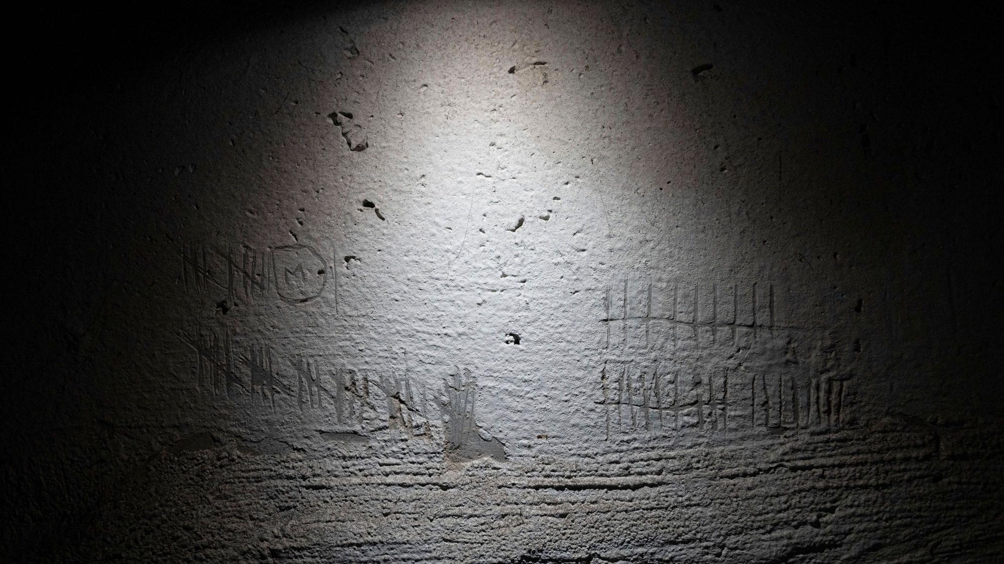 Blick auf Ziffern, die zur Zeitmessung von Häftlingen in die Wand eines Kellers in einem Gebäude in Cherson geritzt wurden, das nach Angaben eines Staatsanwalts für Kriegsverbrechen von russischen Streitkräften als Folterstätte genutzt wurde.