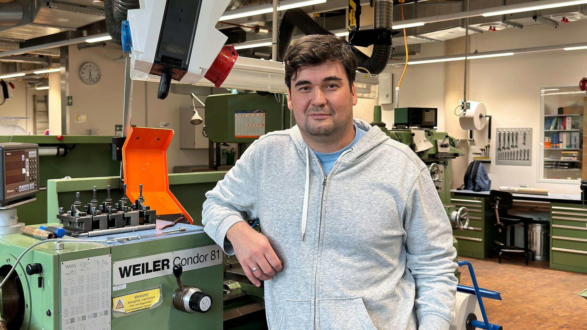 Ein Mann steht vor einer Maschine.