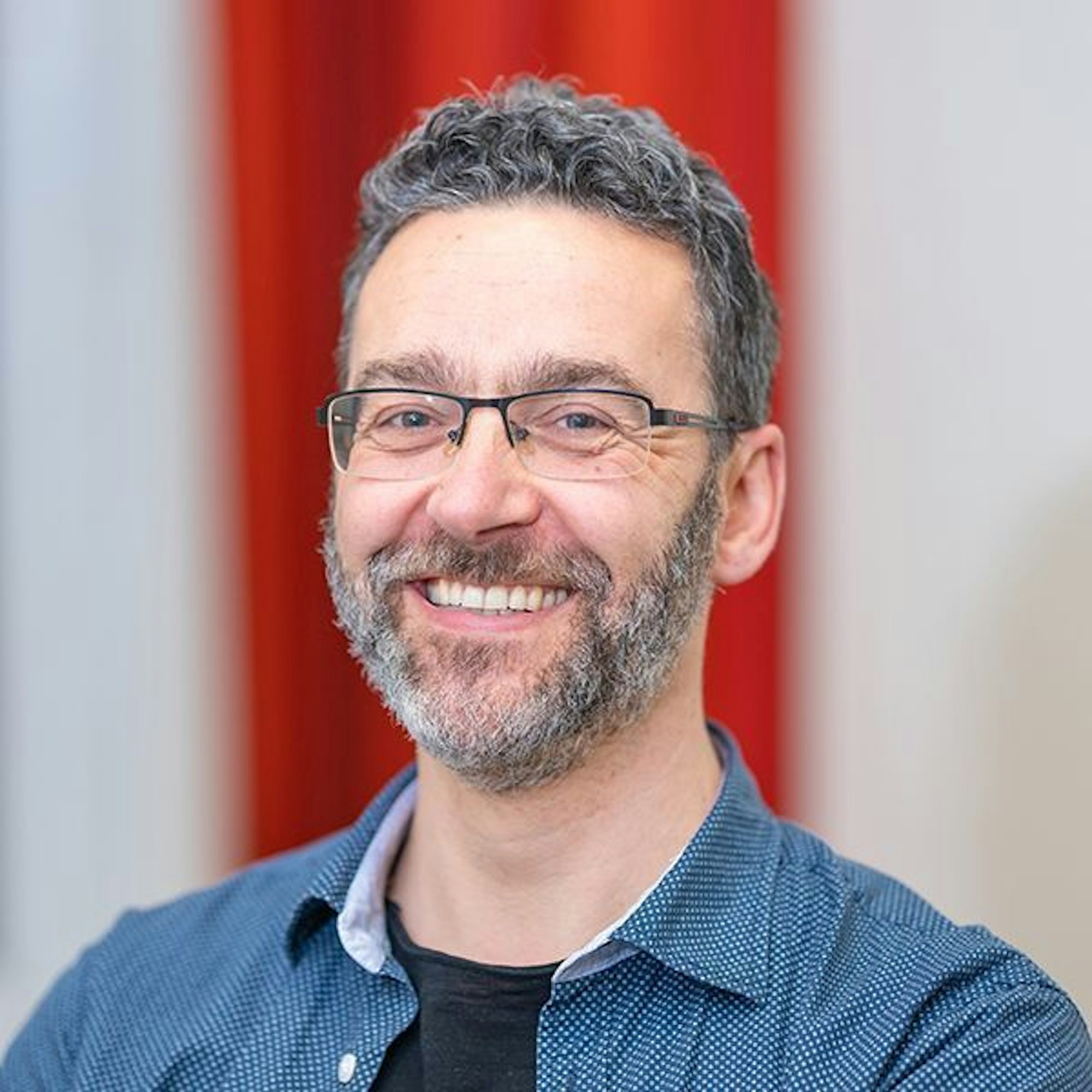 Kinderarzt Axel Gerschlauer ist im Porträt zu sehen, er lacht in die Kamera.