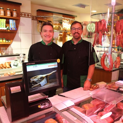 Zwei Männer hinter der Bedientheke einer Metzgerei.