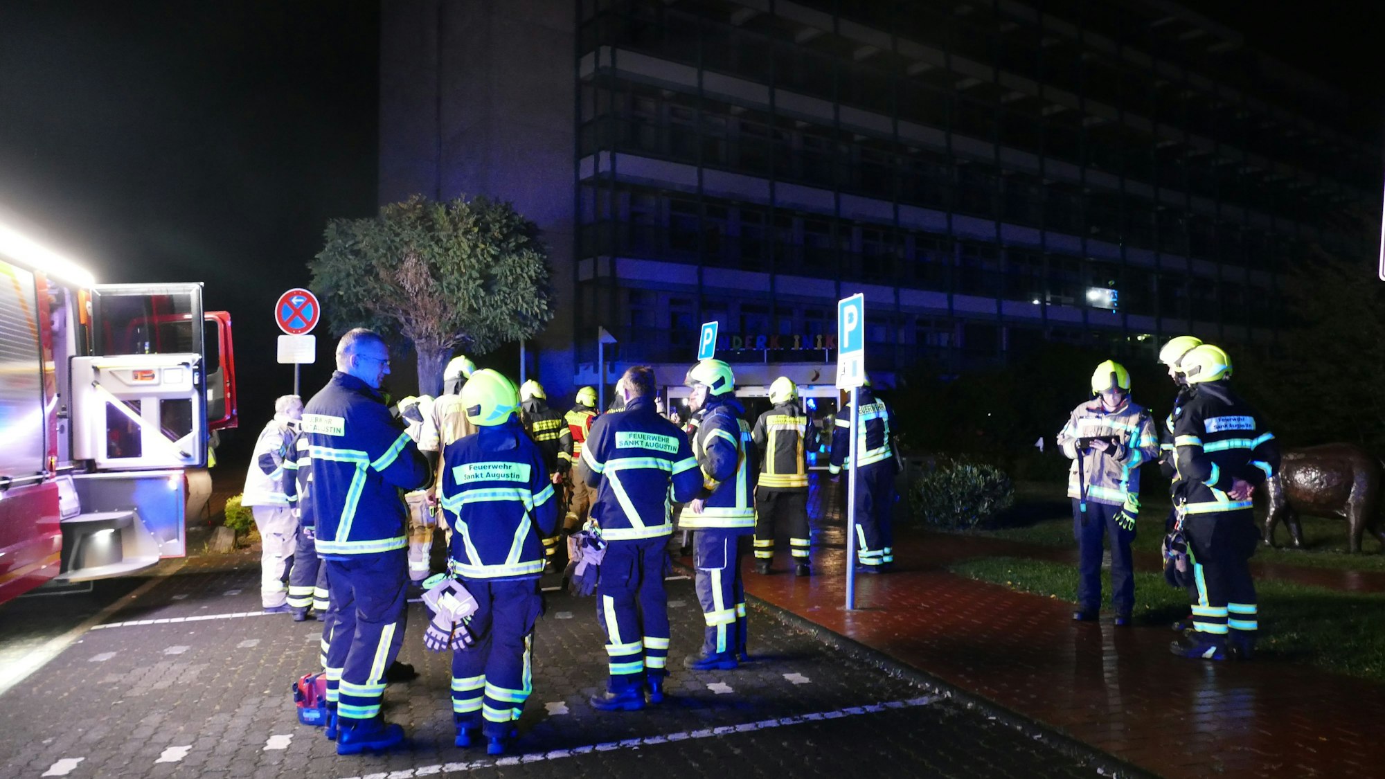Feuerwehrleute stehen vor der dunklen Sankt Augustiner Kinderklinik.