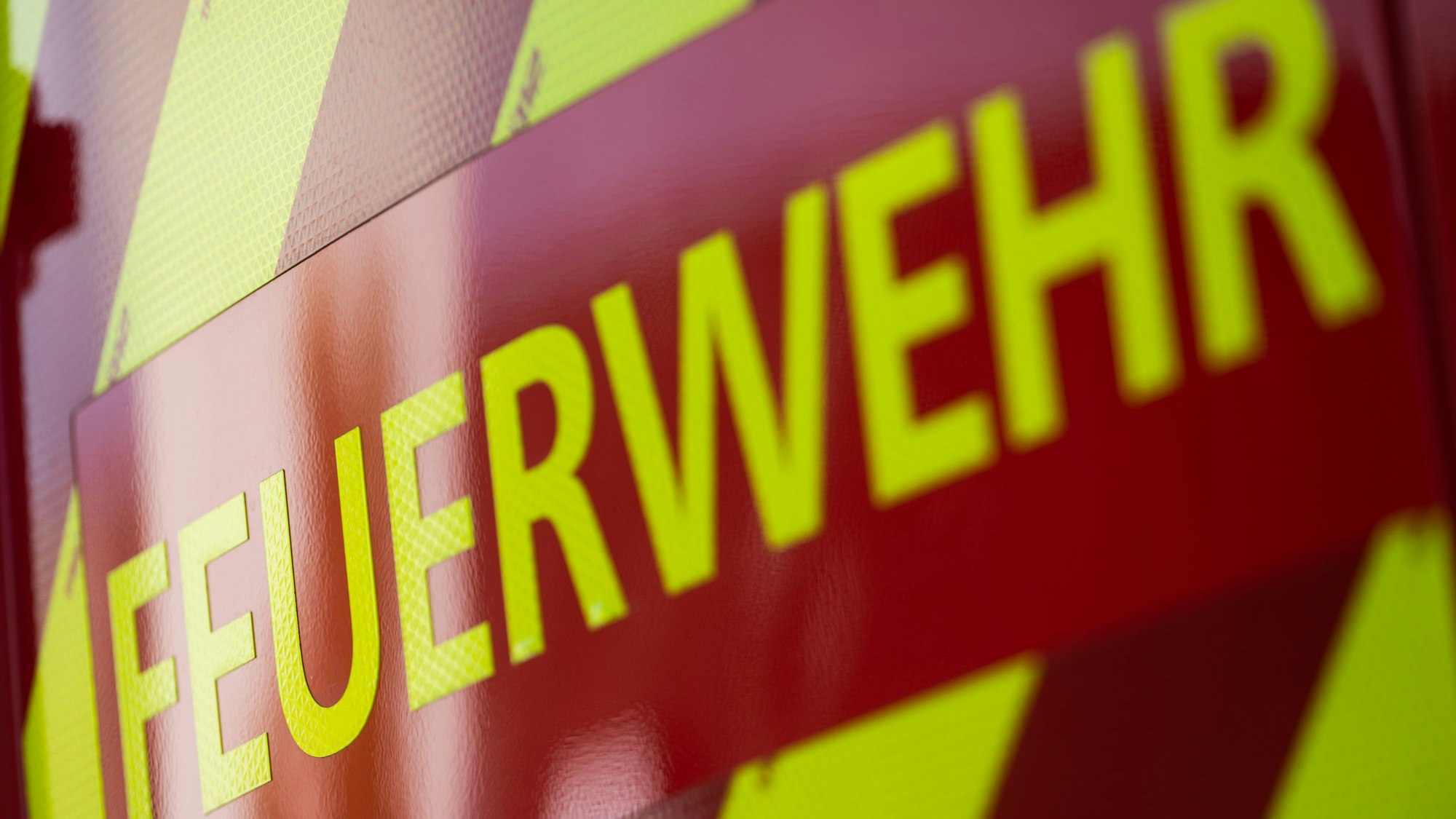 Das Bild ist ein Symbolfoto und zeigt den Schriftzug Feuerwehr auf einem Einsatzfahrzeug.