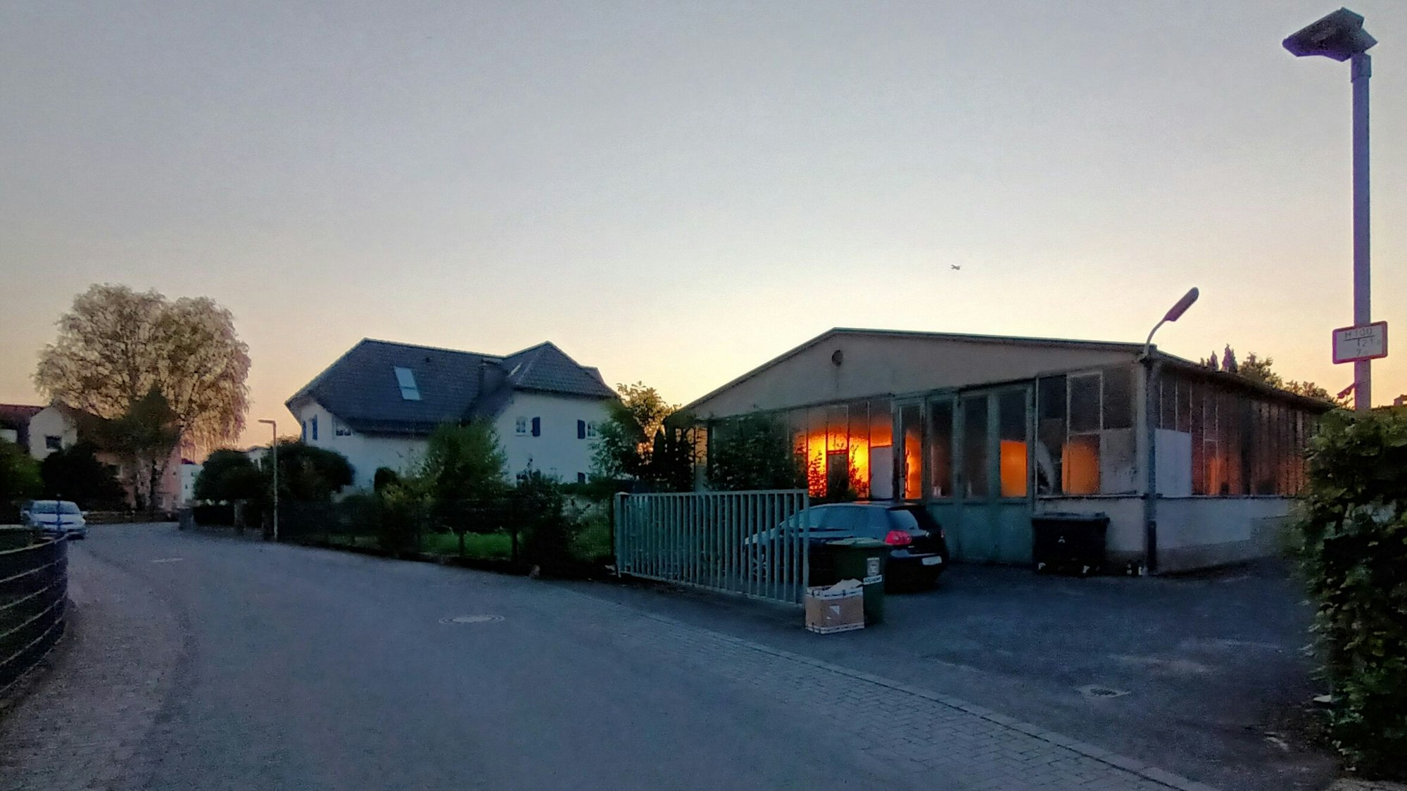 Wohnstraße mit Einfahrt zu einer abbruchreifen Werkshalle