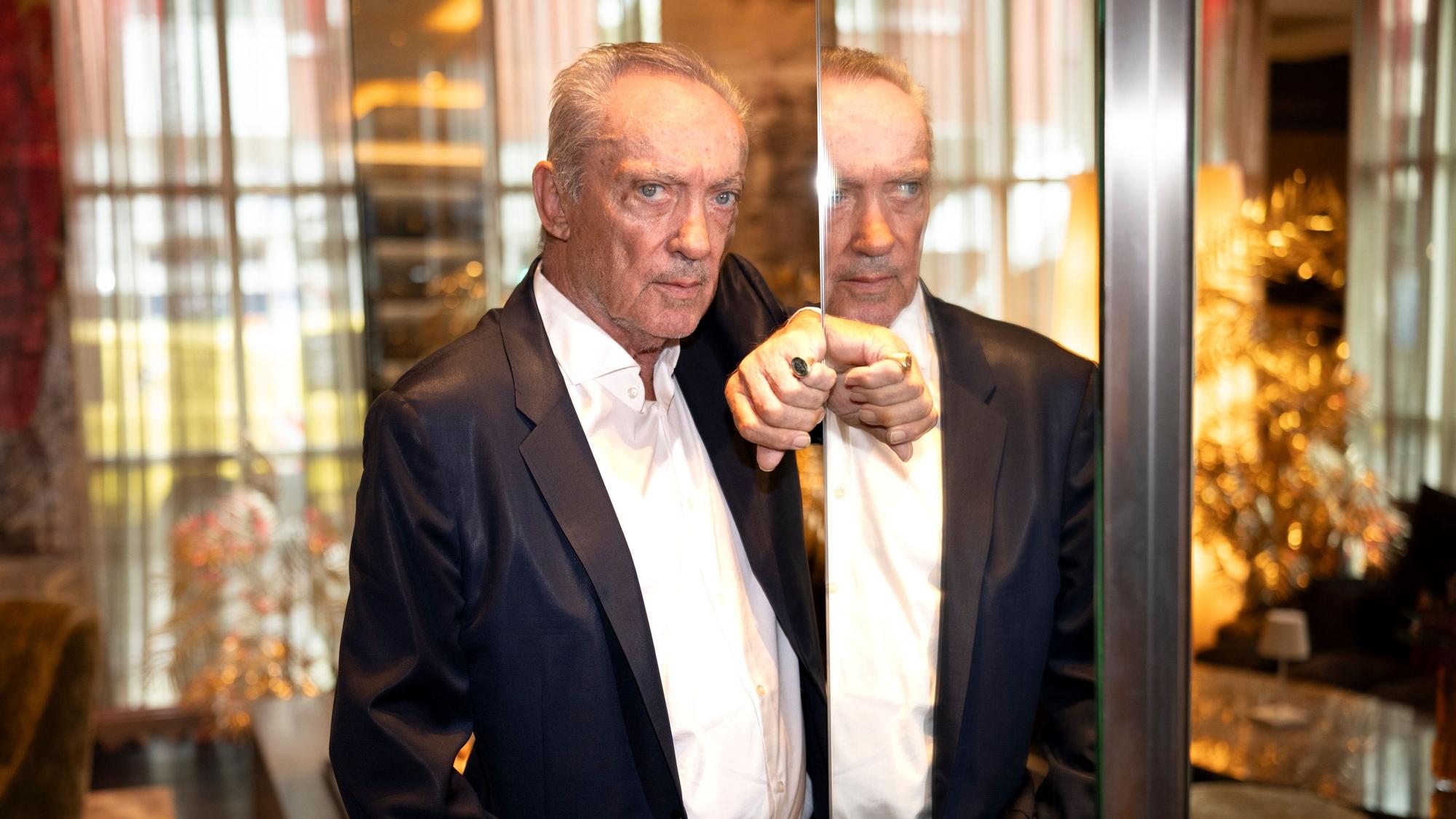 24.09.2024, Köln: Der Schauspieler und Weltstar Udo Kier lehnt an einer Spiegelsäule. Er wird zum 80. Geburtstag vom Kölnischen Kunstverein mit einer Ausstellung geehrt.