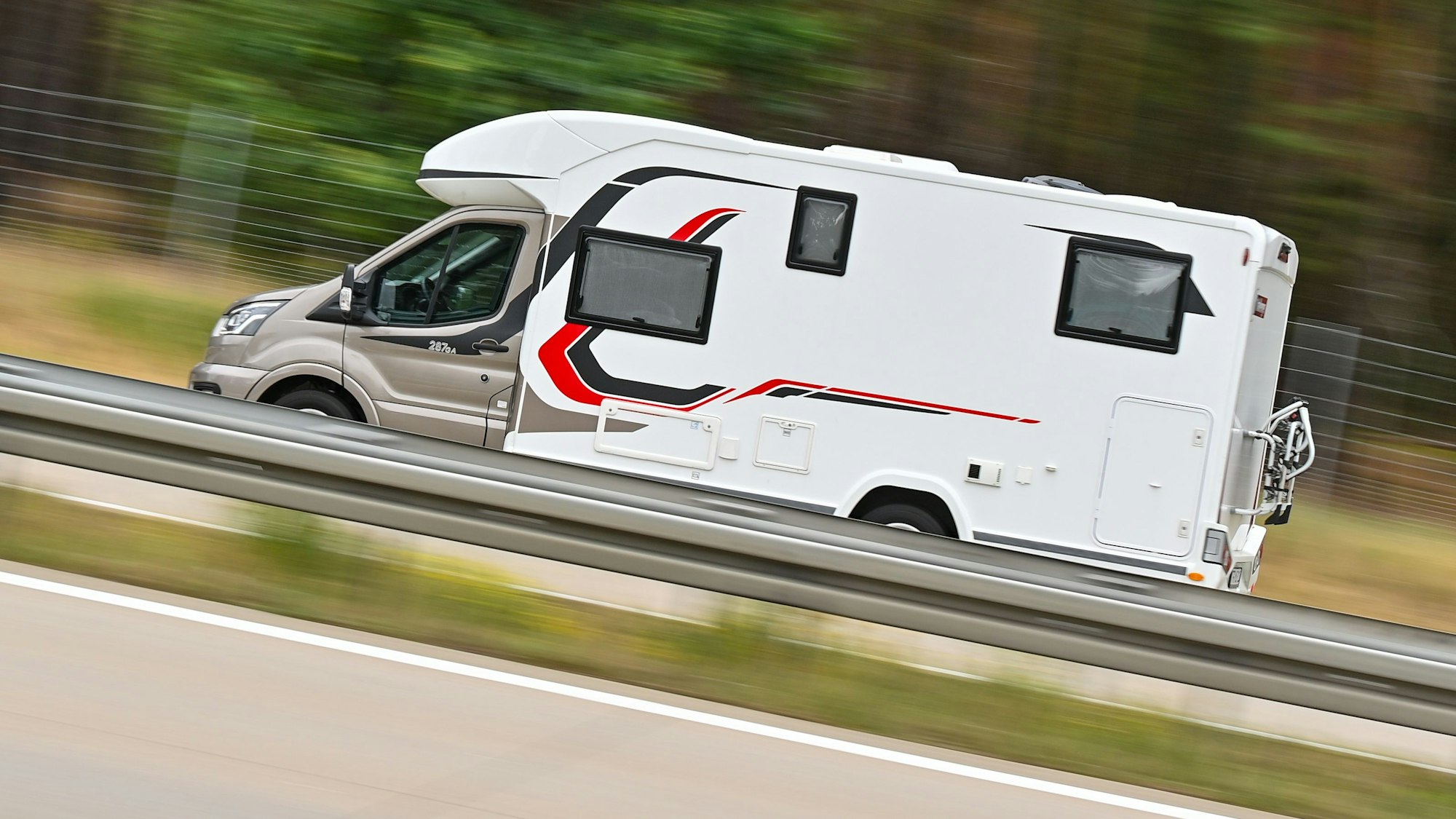 Ein Wohnmobil ist auf einer Autobahn unterwegs.