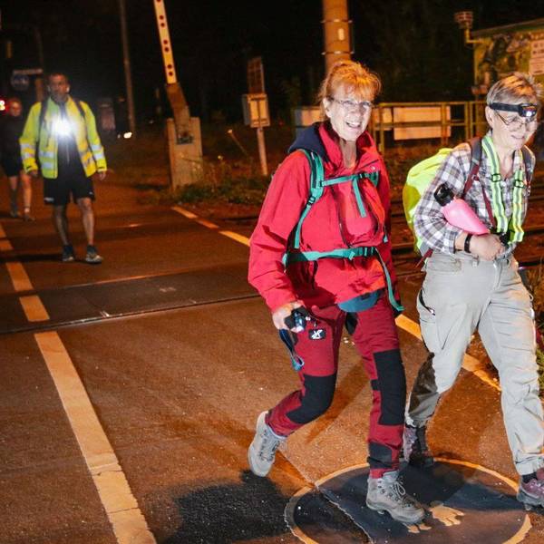 Zwei Frauen marschieren durch die nächtliche Stadt.