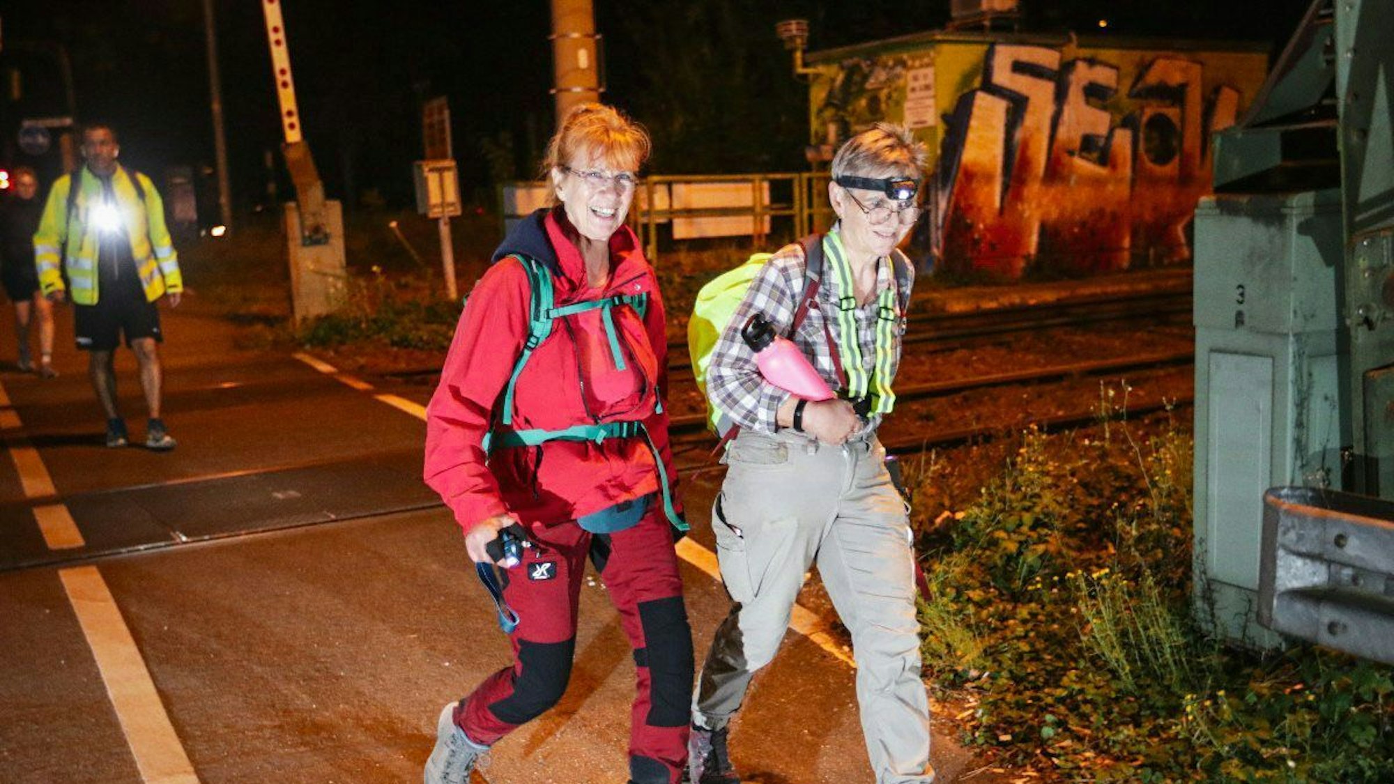 Zwei Frauen marschieren durch die nächtliche Stadt.