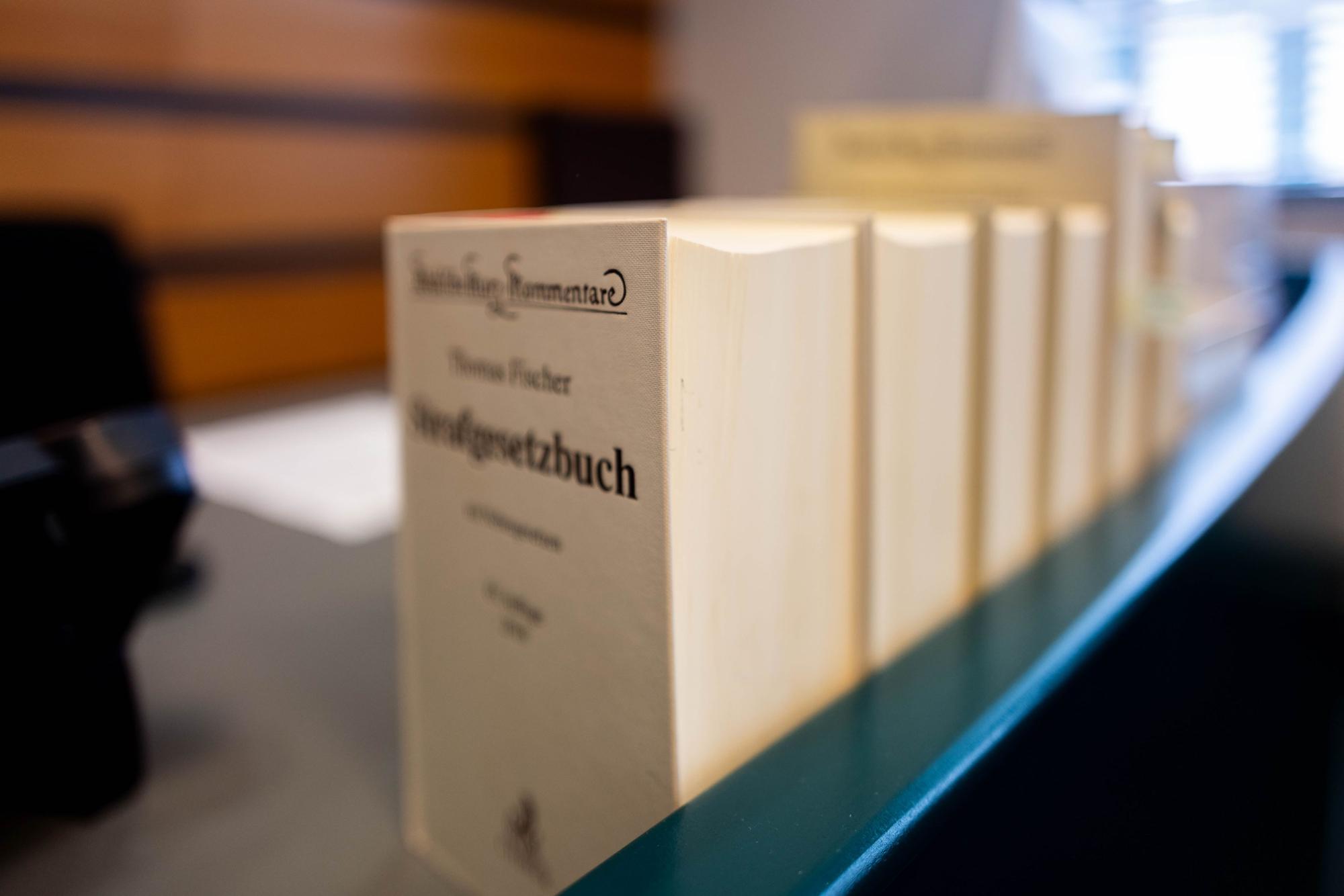 Mehrere Bücher der Strafprozessordnung stehen auf einem Richterpult.